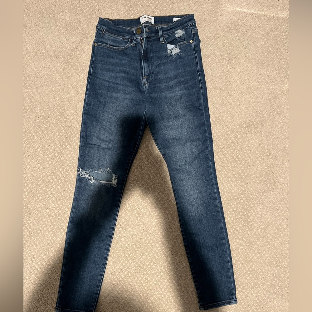 FRAME denim “Le High Skinny” with distressing on one knee.